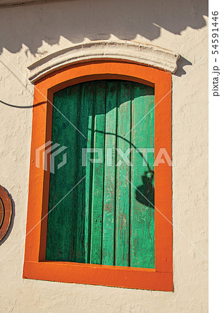 Colorful wooden window with closed green blinds 54591446