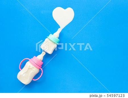 Bottles of milk for baby on blue background. Bottles of milk for baby on blue background. 54597123