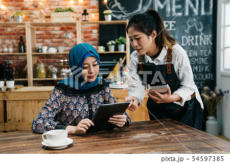 islam businessman reading menu on tablet in cafe 54597385