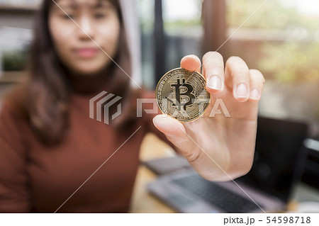 Golden bitcoin (cryptocurrency) in hand of woman. Golden bitcoin (cryptocurrency) in hand of woman. 54598718