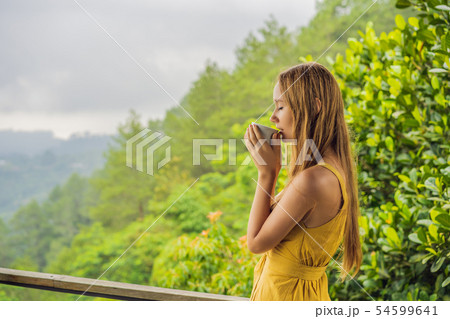 Young woman drinks coffee in a cafe in the mountains 54599641