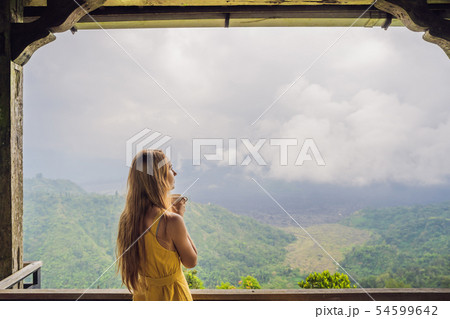 Young woman drinks coffee in a cafe in the mountains 54599642