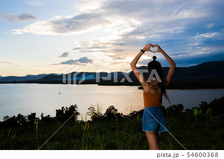 sunset cloud beam to young adult asian woma sunset cloud beam to young adult asian woma 54600368