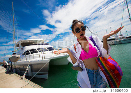 Woman fashion along Luxury Yachts in Marina Bay 54600400