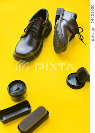 Black leather shoes yellow background top view Black leather shoes yellow background top view 54601000