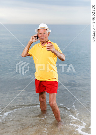 Mature man speaking phone and taking drink Mature man speaking phone and taking drink 54602520