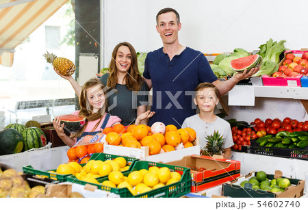 cheerful family near shelves with fruits cheerful family near shelves with fruits 54602740