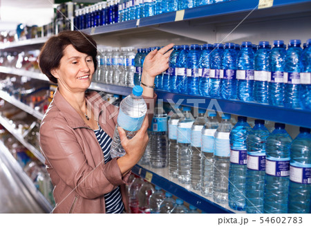 Pensioner selecting a water at the store Pensioner selecting a water at the store 54602783