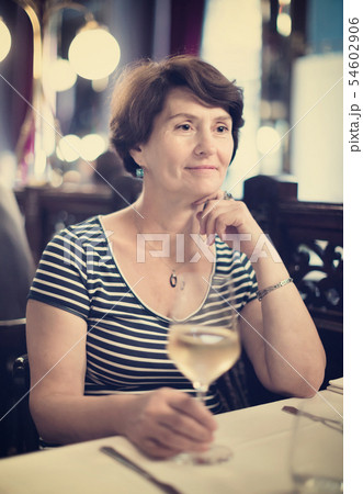 Elderly woman has rest at restaurant with wineglass Elderly woman has rest at restaurant with wineglass 54602906