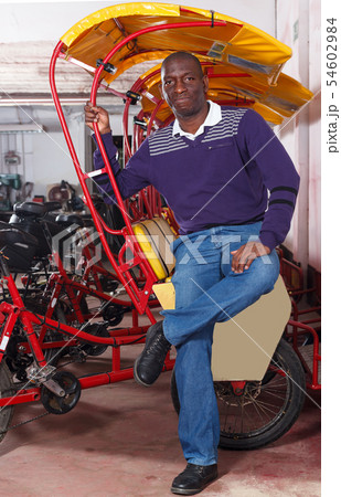 Modern driver of pedicab offering touristic tour Modern driver of pedicab offering touristic tour 54602984