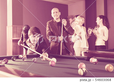 Group of adults playing pool. Group of adults playing pool. 54603068