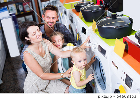 Family of four choosing washing machine Family of four choosing washing machine 54603153