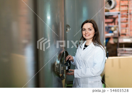Portrait of female engineer rotating valve Portrait of female engineer rotating valve 54603528