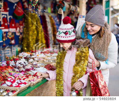 Happy mother with glad little daughter buying decorations for Xmas 54603604