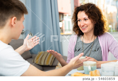 Mother and son enjoying conversation Mother and son enjoying conversation 54603859