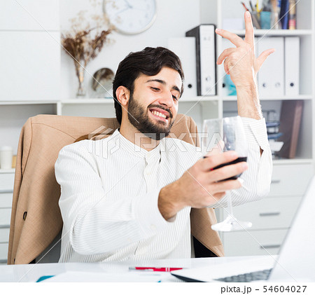Office worker holding glass of wine 54604027