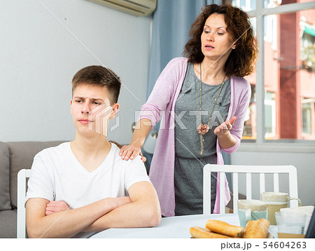 Worried mother talking to son 54604263