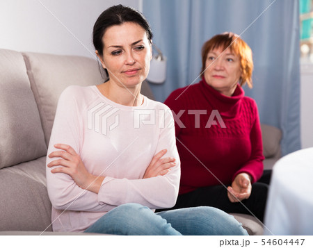 Sad mature female and daughter at sofa after quarrel 54604447