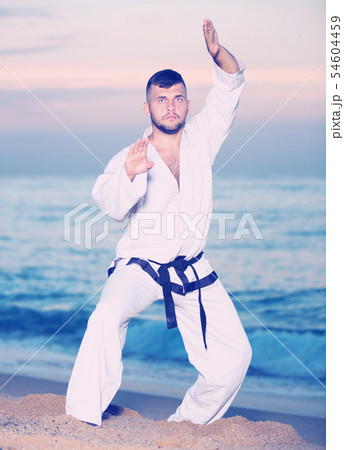 Ordinary man doing karate at ocean quay 54604459
