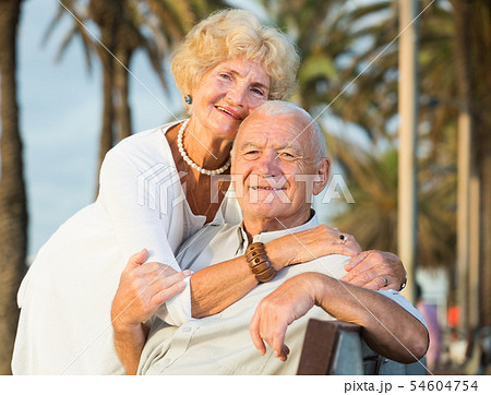 cheerful woman and man sitting outdoors 54604754
