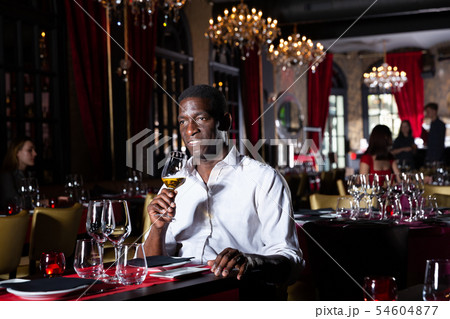 Afro man sitting in restaurant Afro man sitting in restaurant 54604877