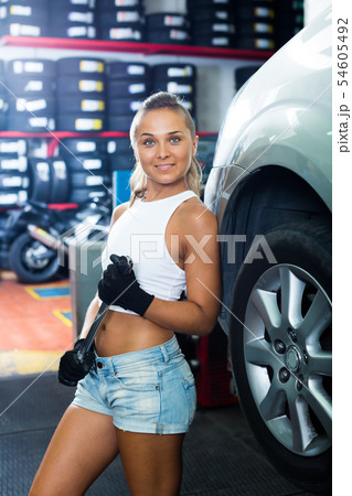 Happy technician girl working in car workshop Happy technician girl working in car workshop 54605492