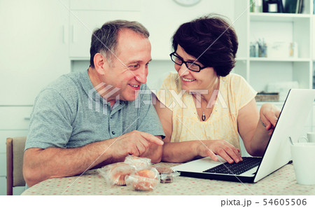 Mature man and woman looking at laptop 54605506