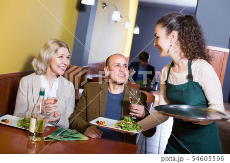 Waitress serving senior customers . Waitress serving senior customers . 54605596
