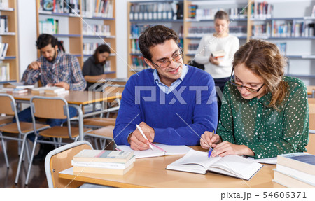 Young people preparing for exam in library Young people preparing for exam in library 54606371