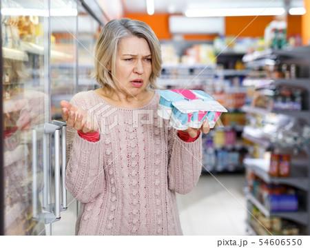 Woman reading product label 54606550