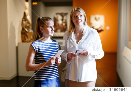 Girl with woman looking with interest at ancient sculptures in museum 54606644