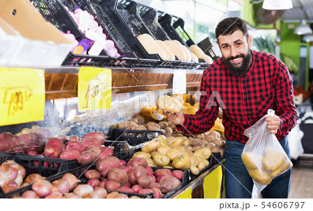 Young male seller offering potatoes Young male seller offering potatoes 54606797