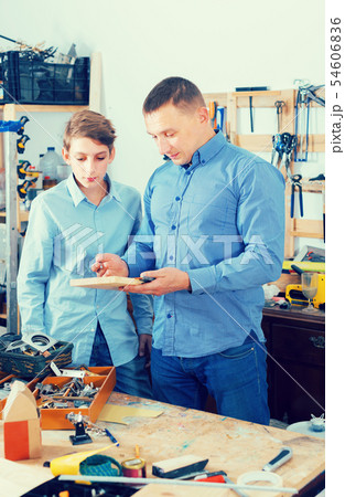 adult father teaching son сarpentry in the garage adult father teaching son сarpentry in the garage 54606836