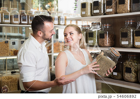 Couple picking glass can with dried herbs Couple picking glass can with dried herbs 54606892