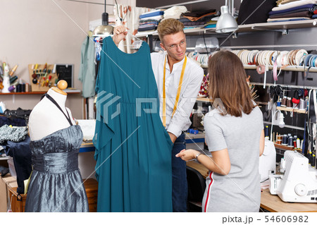Tailor showing customer dress 54606982