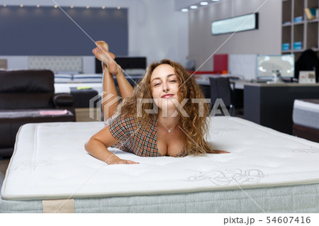 Woman choosing mattress in furnishings store 54607416
