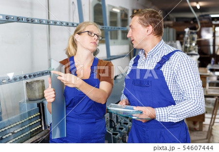Man and woman working in glass workshop Man and woman working in glass workshop 54607444