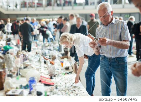 Elderly man and woman consider things in flea market Elderly man and woman consider things in flea market 54607445