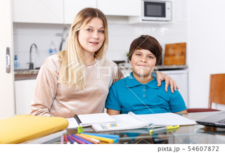 Family doing homework at kitchen Family doing homework at kitchen 54607872