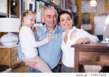 Couple with daughter choosing new furniture in store 54607926