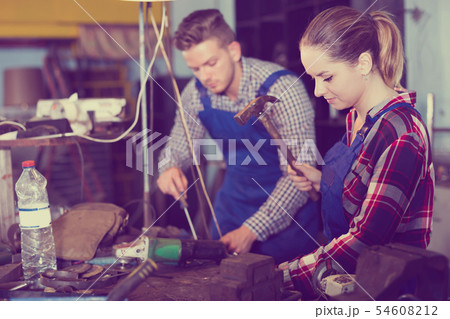 Young woman master is working with hammer Young woman master is working with hammer 54608212