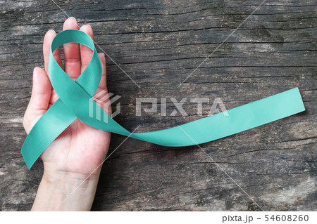 Teal ribbon awareness on hand for Ovarian Cancer Teal ribbon awareness on hand for Ovarian Cancer 54608260