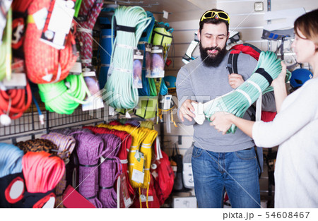 Positive guy choosing climbing equipment in store Positive guy choosing climbing equipment in store 54608467