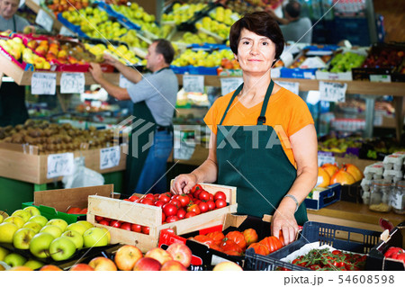 Portrait of smiling woman seller who is standing in the vegetables store. 54608598