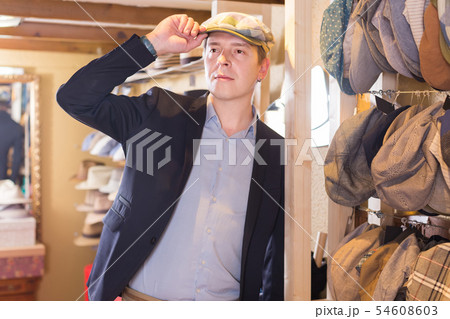 portrait of young male try on newboy cap at the shopping mall portrait of young male try on newboy cap at the shopping mall 54608603