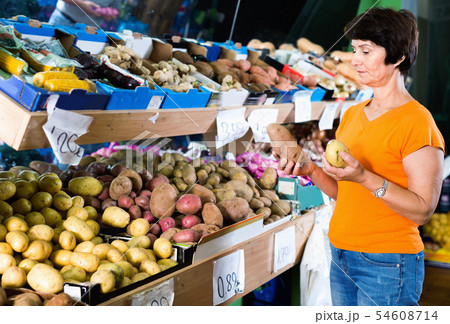 Smiling female is choosing potato in the supermarket. 54608714