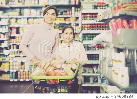 Woman with daughter in supermarket Woman with daughter in supermarket 54609334