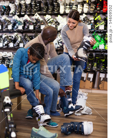 Young woman helping her husband and son choose new ski boots 54609502