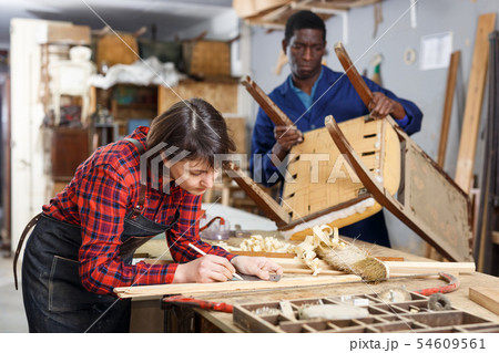 Artisans in process of renewing armchair Artisans in process of renewing armchair 54609561