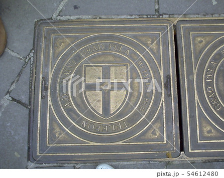 An iron manhole cover in a street of Pula, 54612480